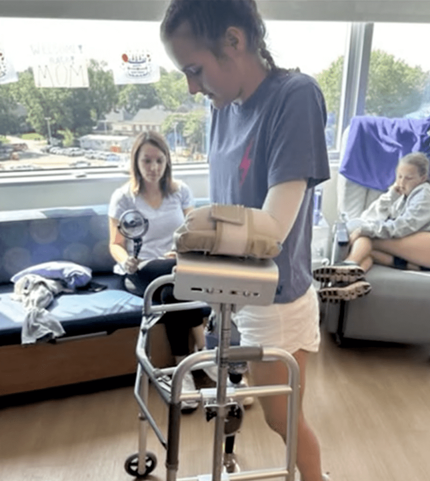 Teen shark attack survivor Lulu Gribbin using a walker with a prosthetic leg.