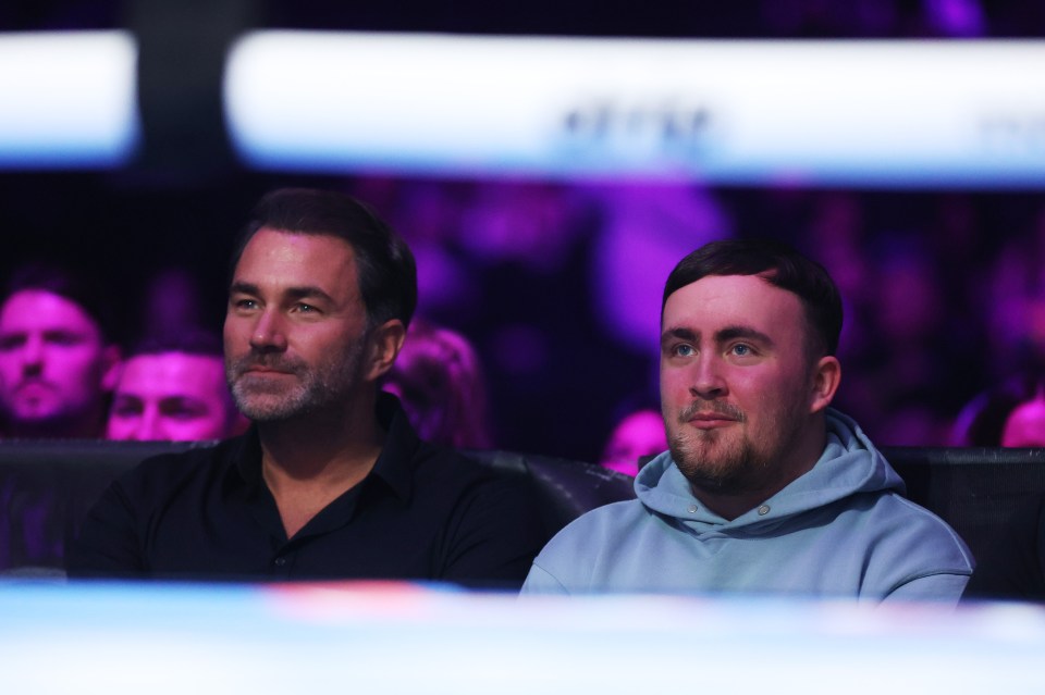 Professional darts player Luke Littler and Eddie Hearn watching a boxing match.
