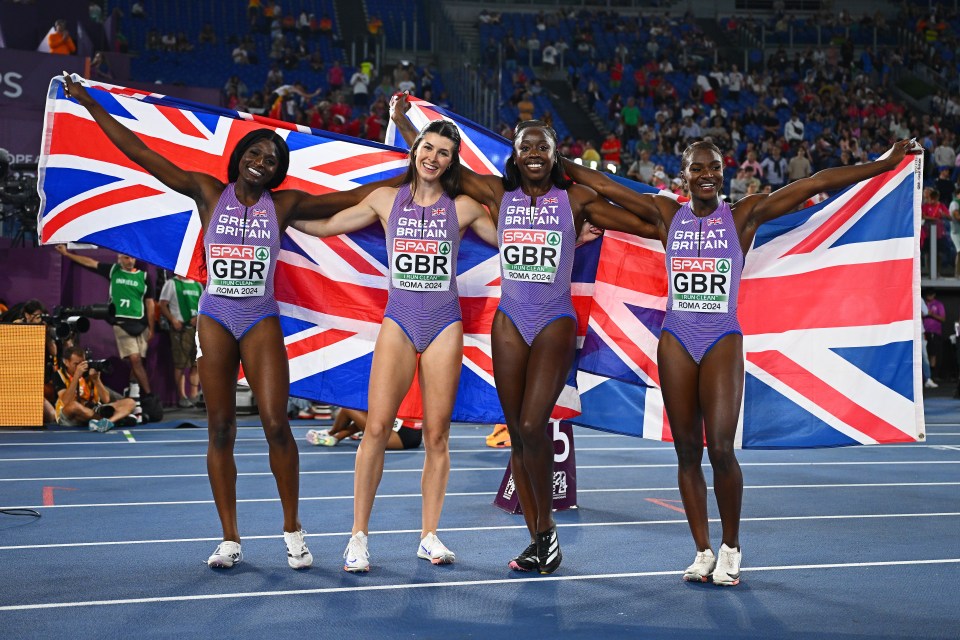 Four gold medalists from Team Great Britain celebrate in purple tracksuits while holding the Union Jack flag.