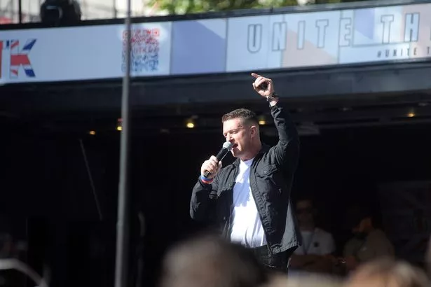 LONDON, ENGLAND - SEPTEMBER 13: British far-right activist Tommy Robinson, whose real name is Stephen Yaxley-Lennon, speaks to the crowd on September 13, 2025 in London, England. Far-right activist Tommy Robinson (also known as Stephen Yaxley-Lennon) has invited supporters to hold a rally in central London entitled "Unite The Kingdom". The former English Defence League leader  and his supporters are actively islamaphobic and racist and have been behind much of the unrest seen outside hotels housing migrants this summer. Stand Up To Racism are mounting a counter-protest to today's rally. (Photo by SAV/Getty Images)