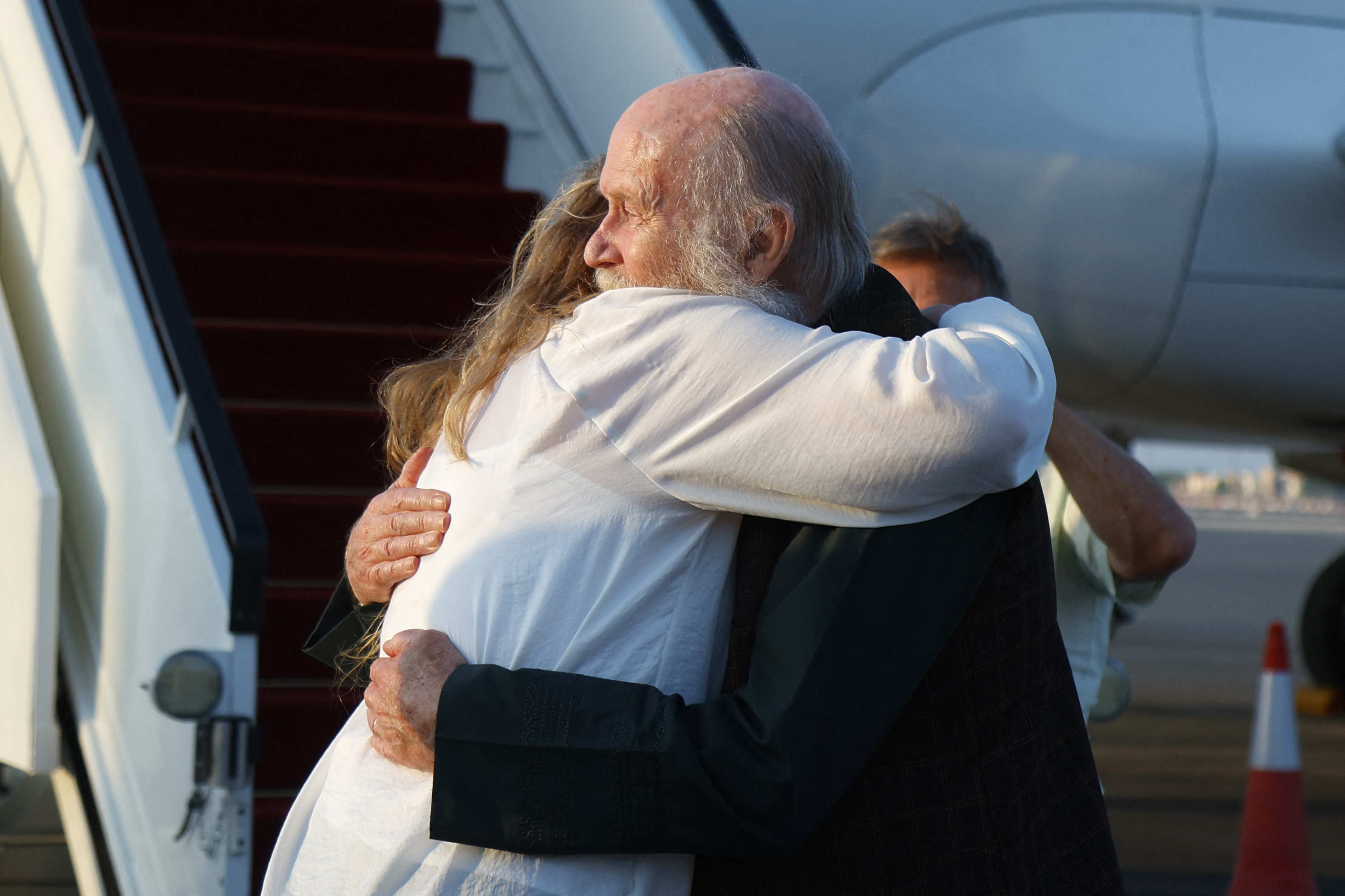 Peter Reynolds hugs his daughter Sarah Entwistle after landing at the airport in Doha.