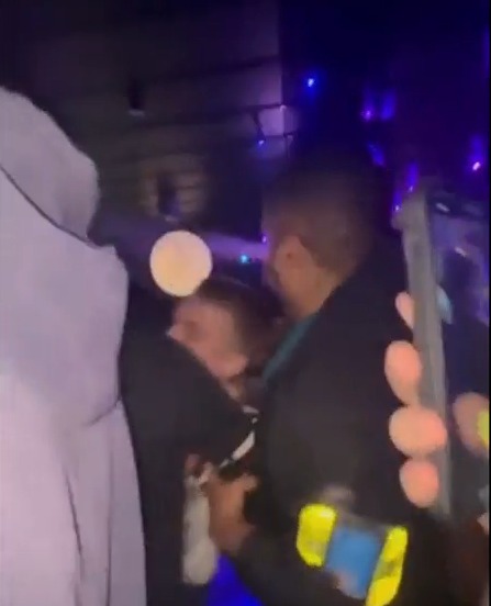 Bonnie Blue being escorted in a dimly lit club after an alleged assault.