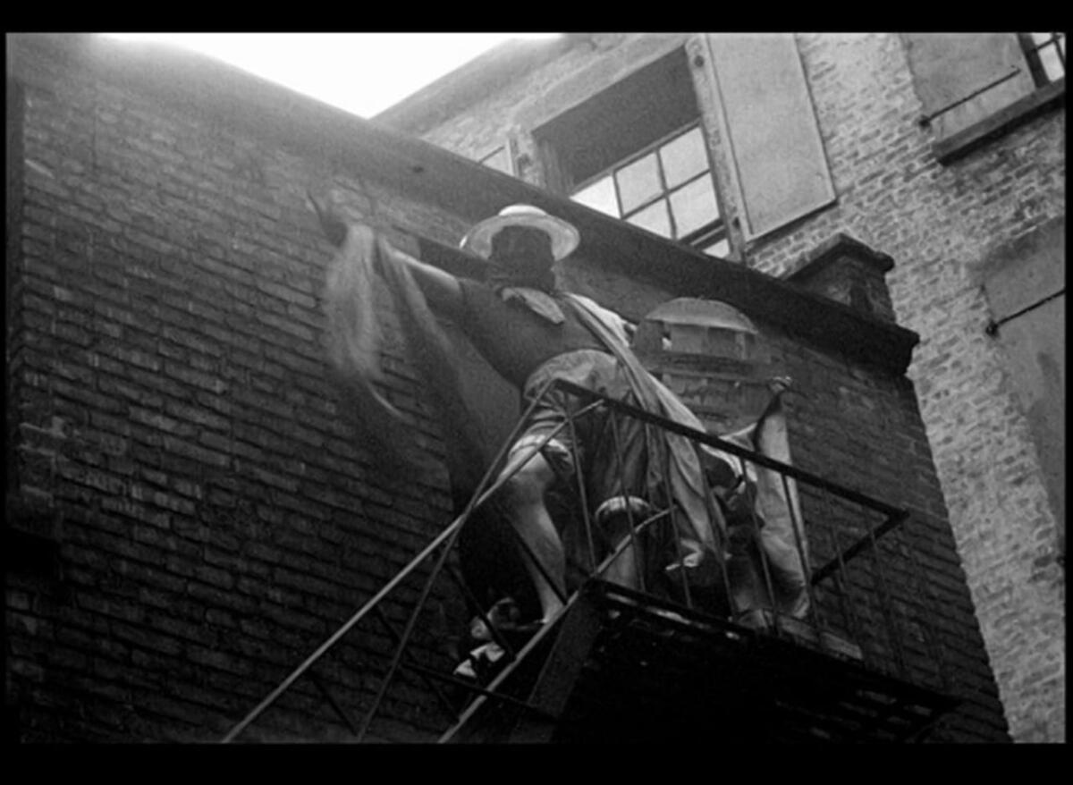A man stands by a building.