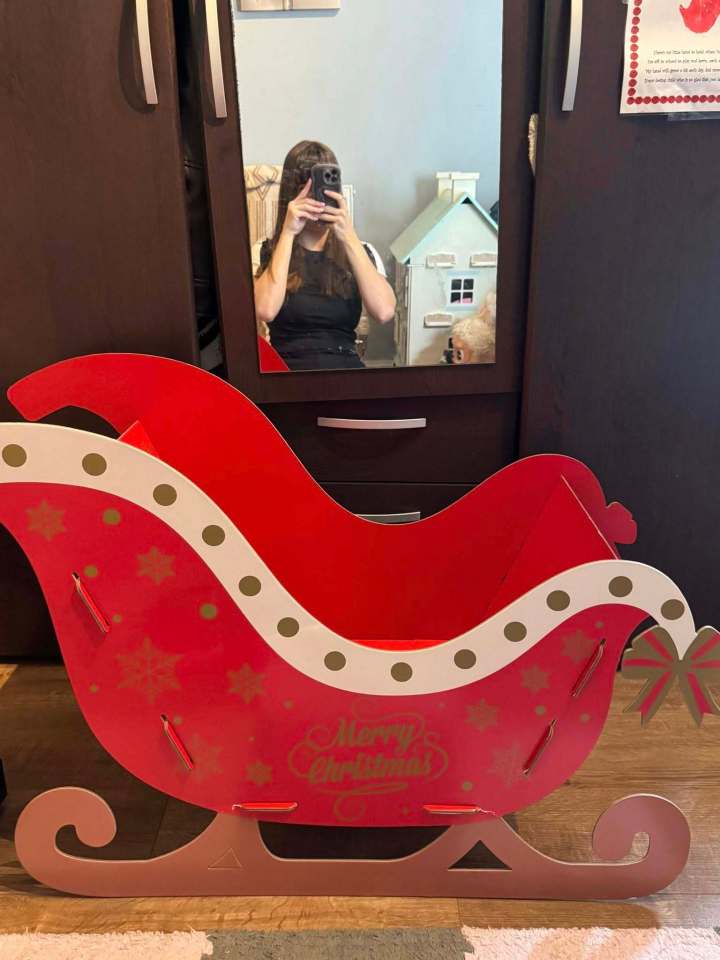 Red cardboard Christmas sleigh with "Merry Christmas" written on the side.