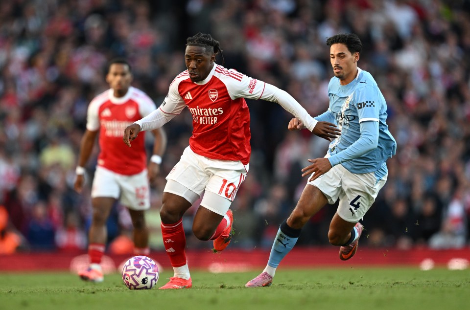 Eberechi Eze of Arsenal runs with the ball under pressure from Tijjani Reijnders of Manchester City.