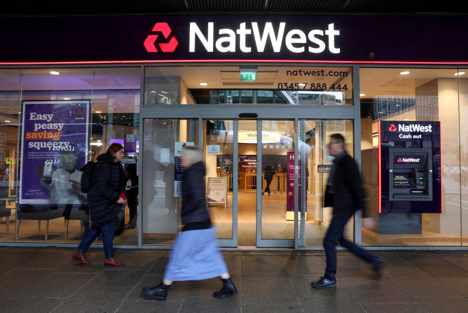 People walk past a NatWest bank branch.