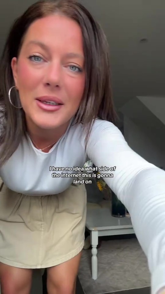 A woman in a white shirt and beige skirt looking into the camera.