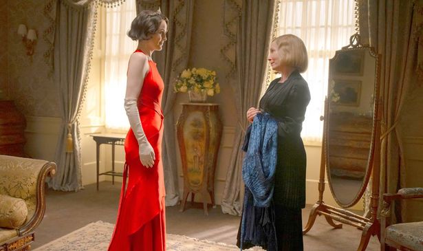 A woman in a red dress talks to a woman in blue