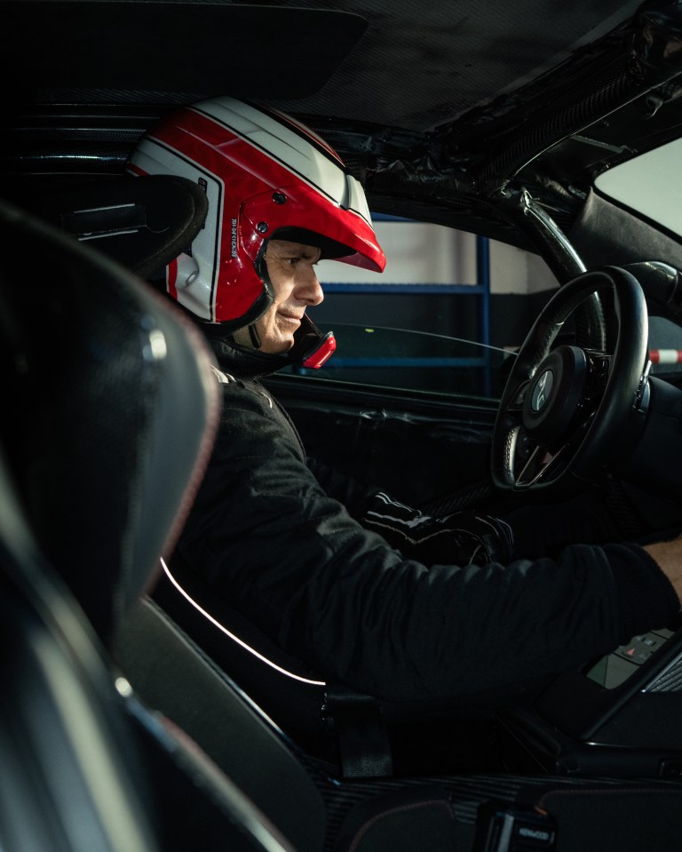 Driver in red and white racing helmet and suit sitting inside the YANGWANG U9 Xtreme.