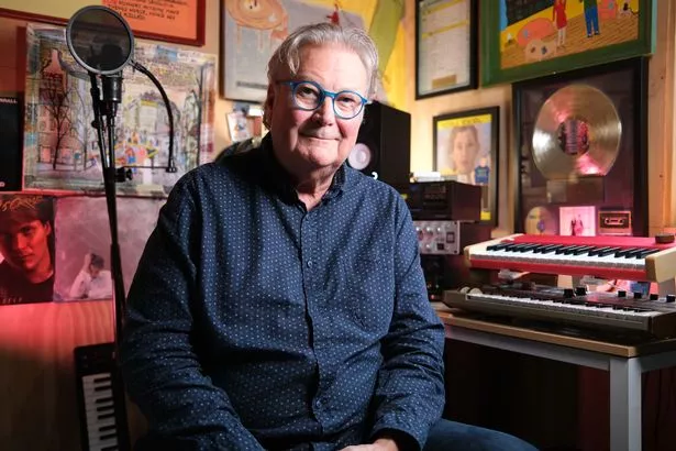 Songwriter Robert Ellis Orrall wears a blue shirt in his studio