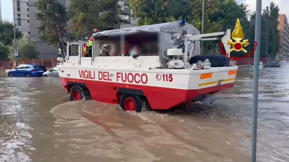 Vigili del fuoco rescuing children from flooded Niguarda in Milan.