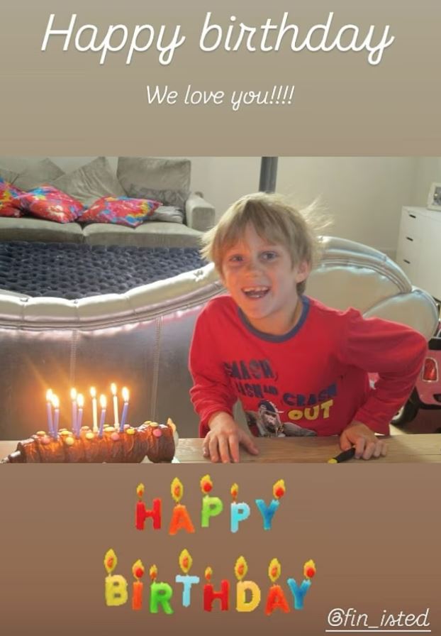 Finley James celebrates his birthday with a birthday cake with lit candles.