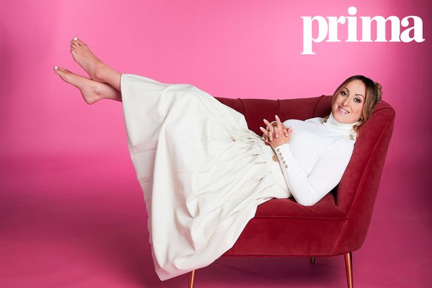 Natalie lying on a sofa in a white dress
