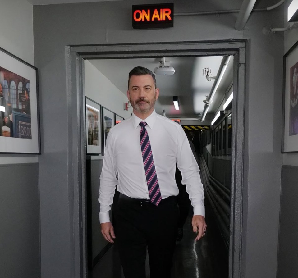 Jimmy Kimmel walking out of a doorway with an "ON AIR" sign above it.
