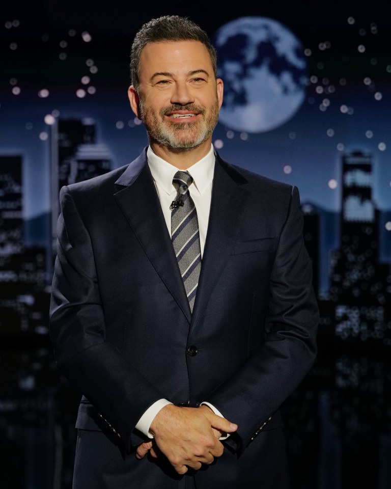 Jimmy Kimmel in a suit against a city skyline and moon backdrop.