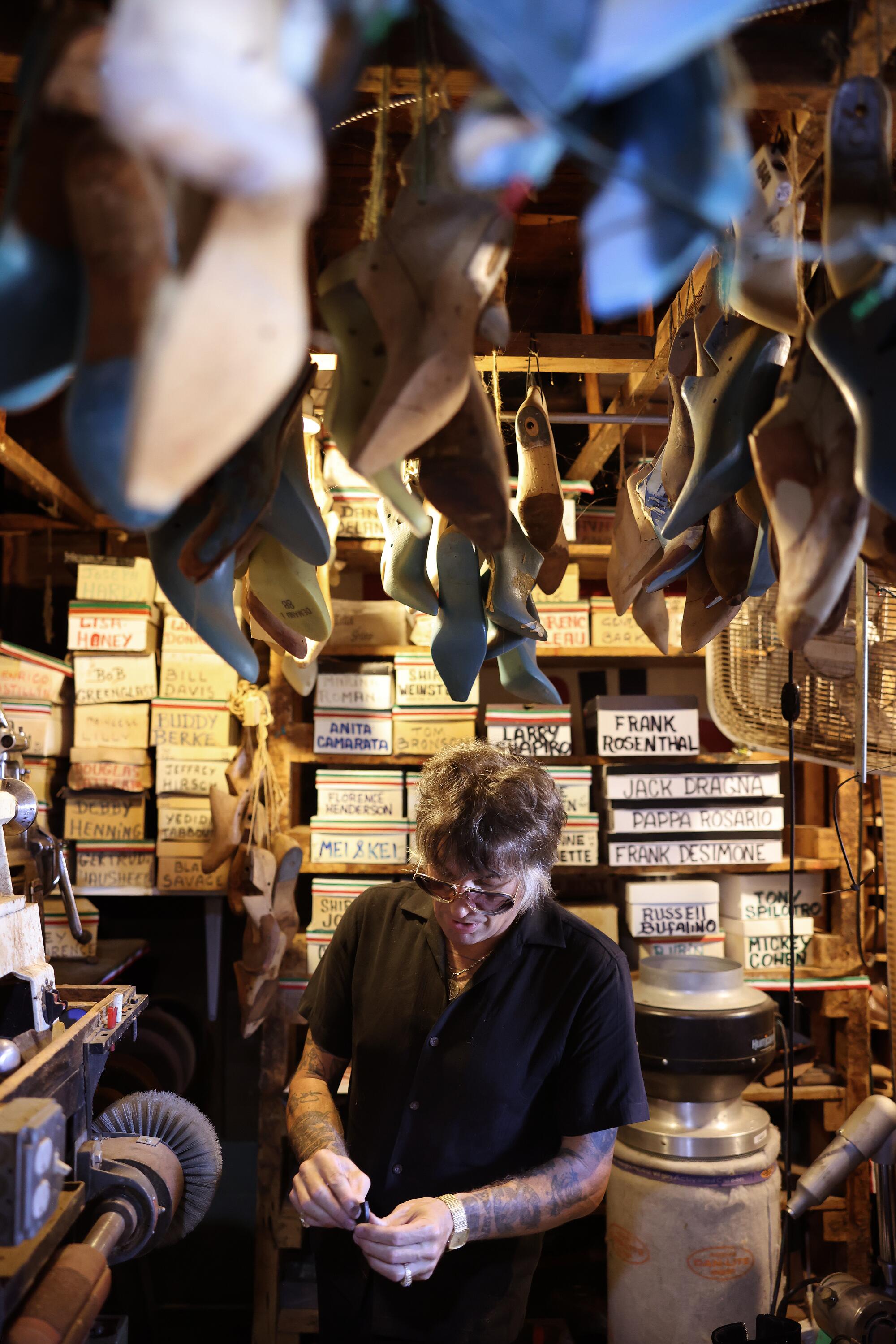 A man makes a pair of shoes in his garage.