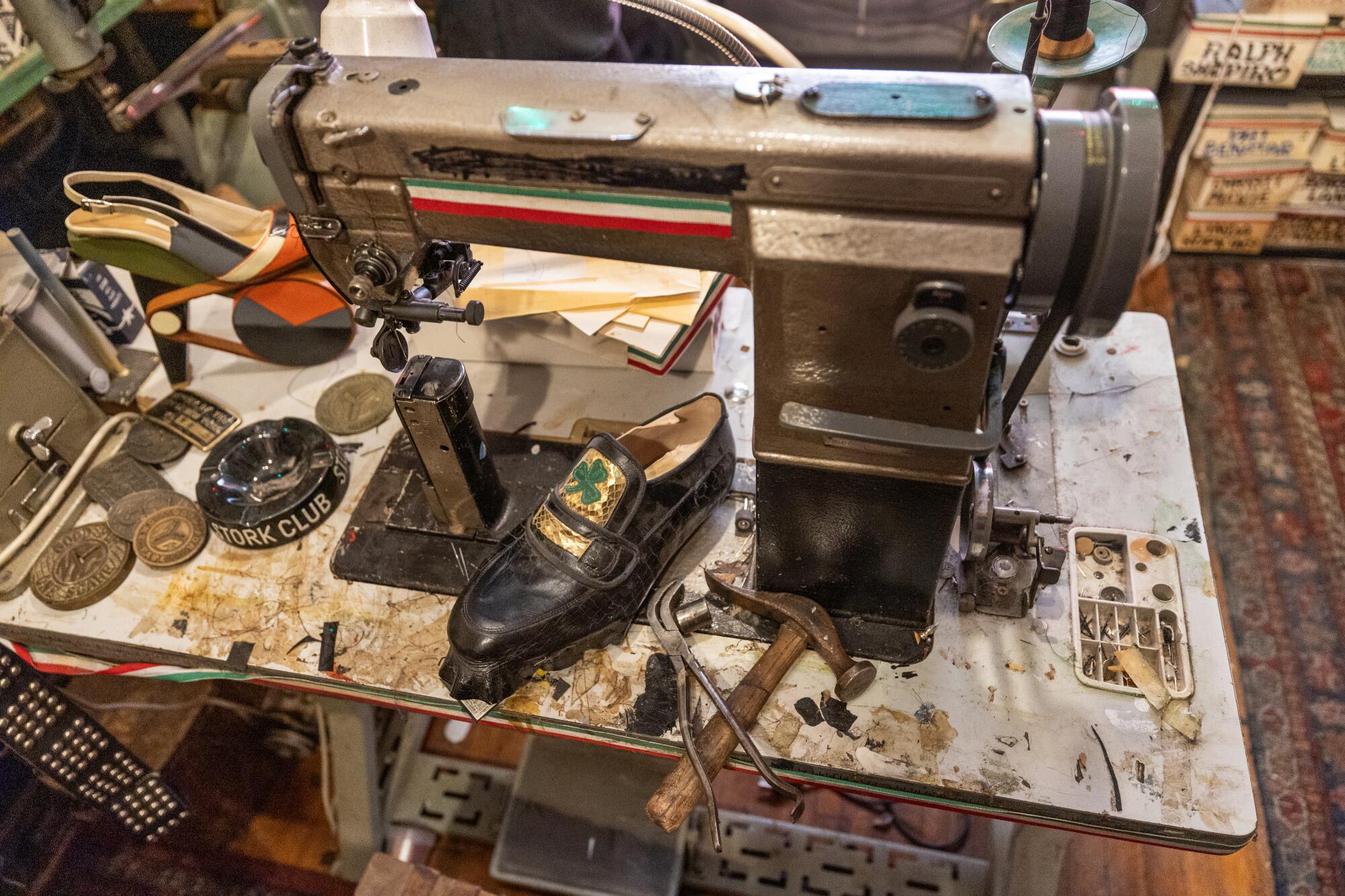 A shoe next to a sewing machine.