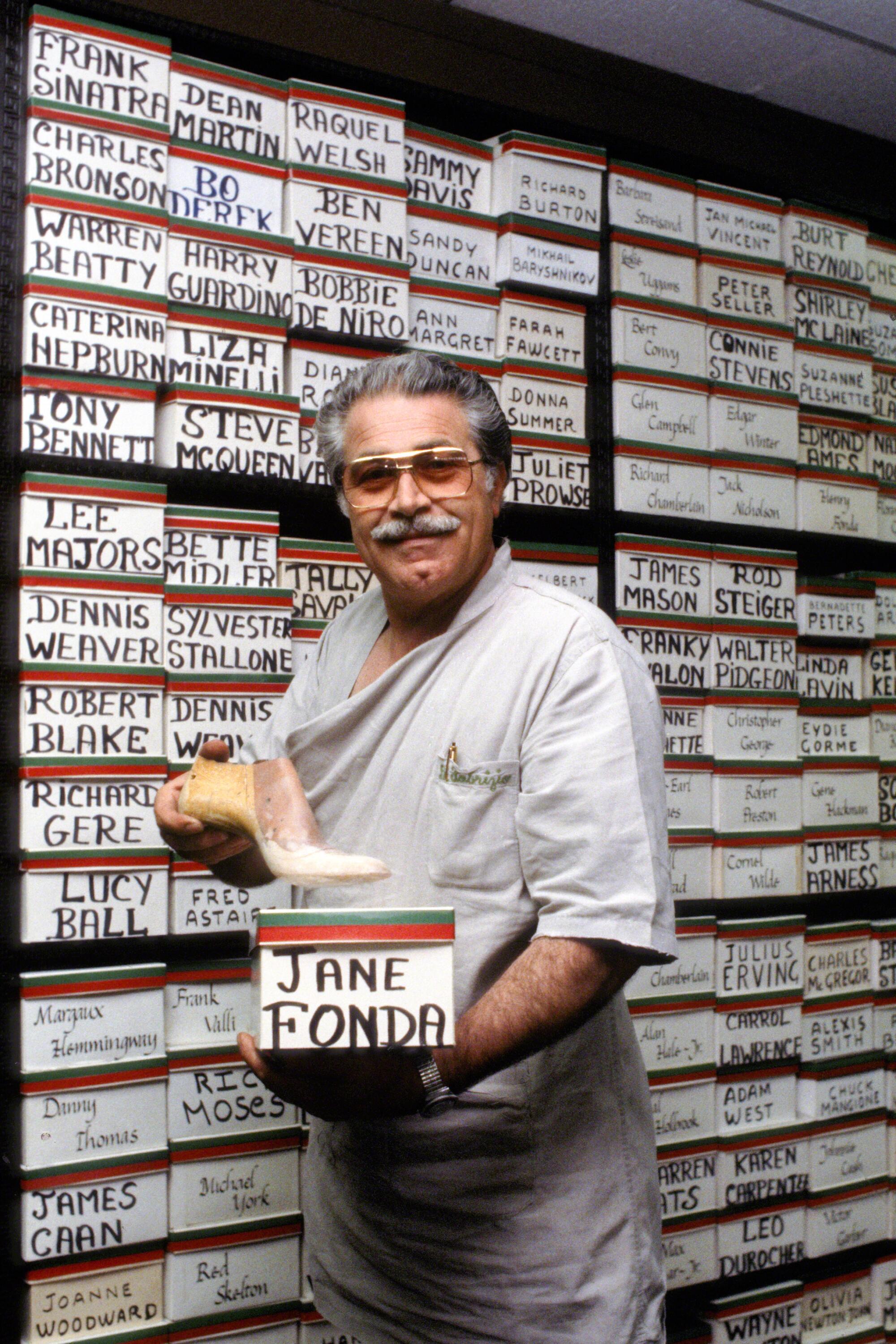 A man in tinted glasses holds a box with the name Jane Fonda on it