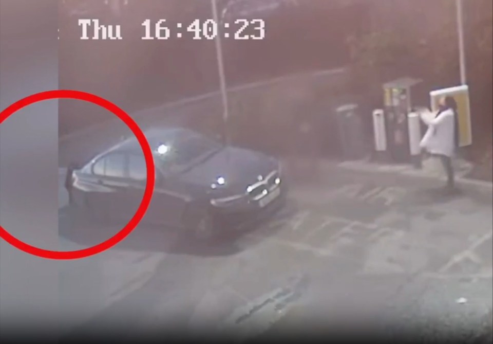 Surveillance footage showing a person dressed in a white coat at a gas station with a black car.