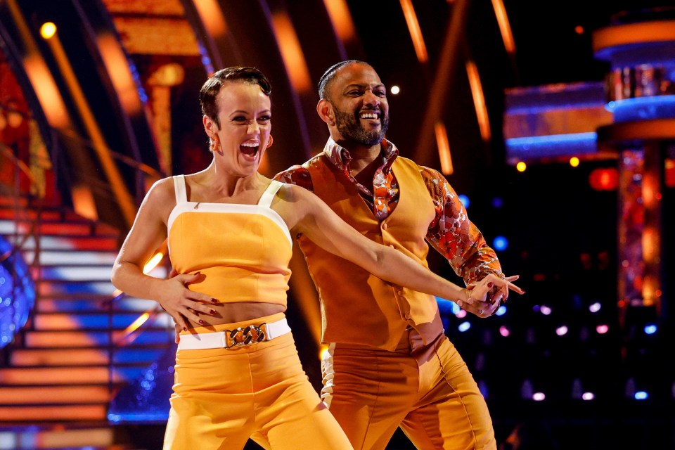 Lauren Oakley and JB Gill performing a dance in orange outfits on Strictly Come Dancing.