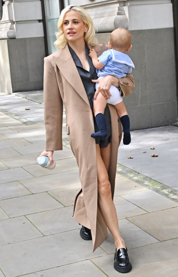 Pixie Lott holding baby Bertie and a Tommee Tippee bottle during London Fashion Week.