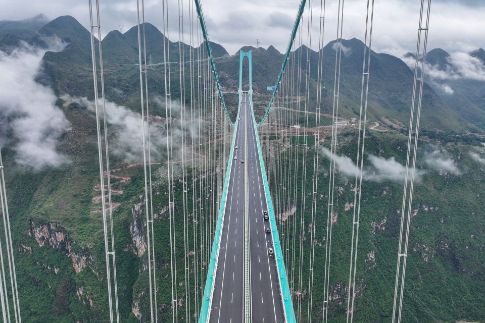 The Huajiang Grand Canyon Bridge in China, the world's highest bridge, spanning a mountainous canyon with a winding river below.