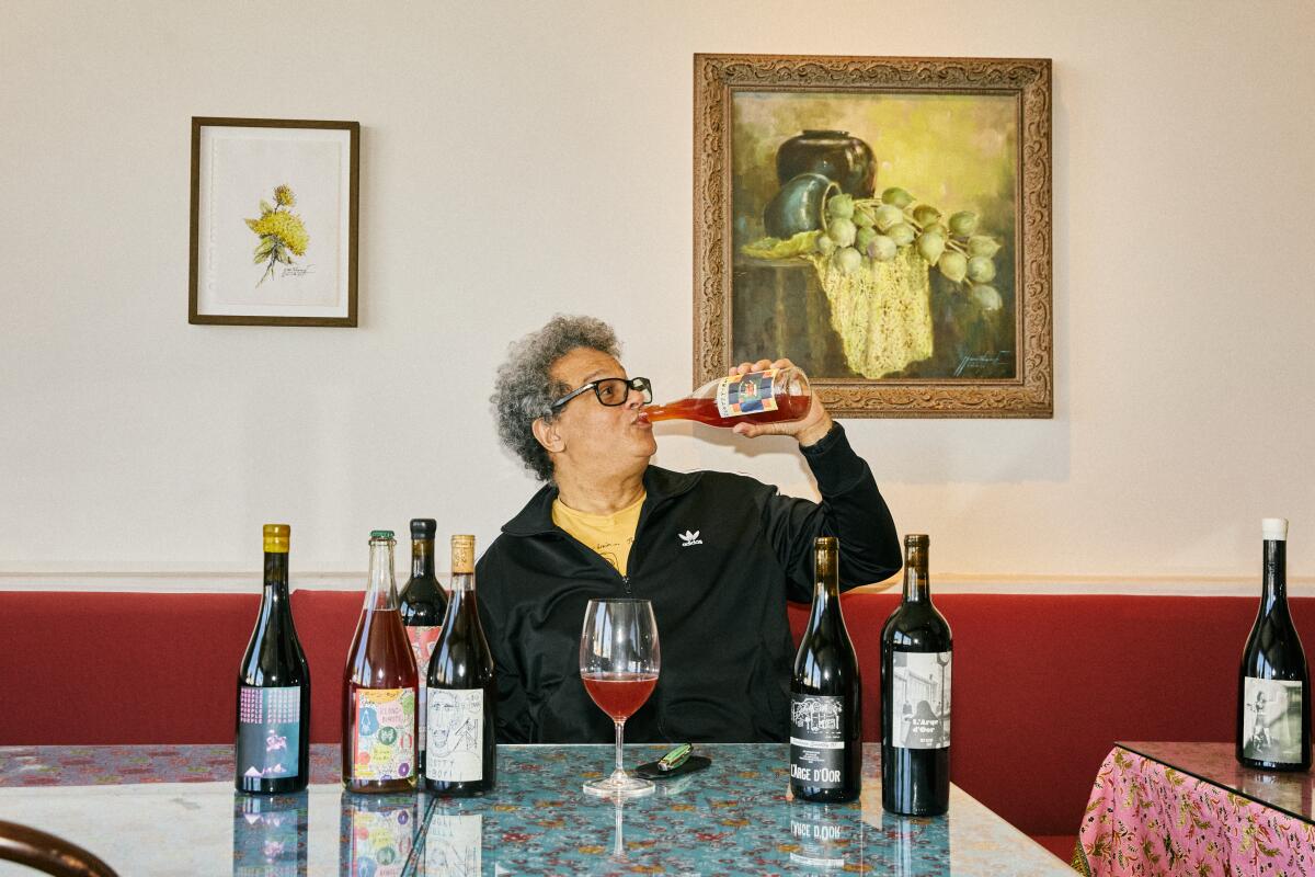 A man chugs a bottle of wine, surrounded by other bottles. LOS ANGELES - SEPTEMBER 4, 2025