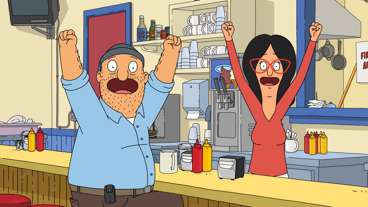 a man and a woman with their arms raised