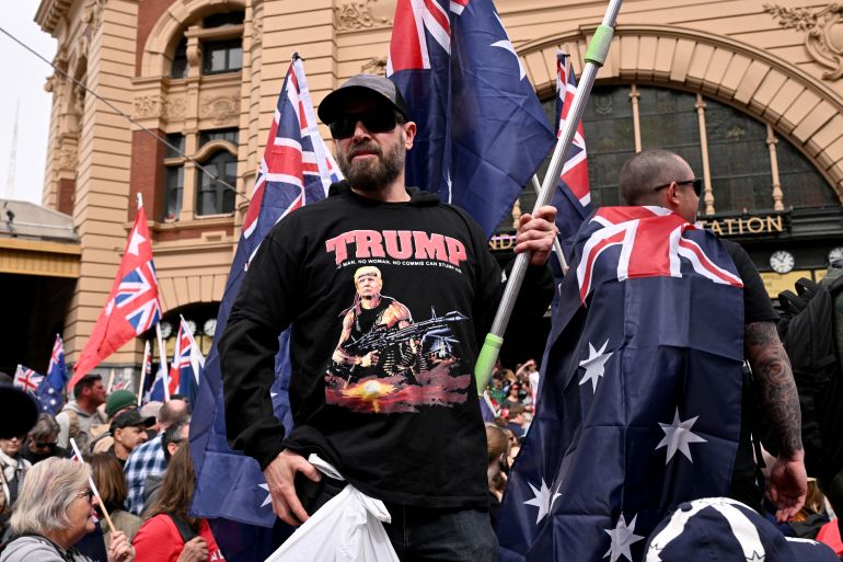 A protester wearing a shirt showing an image of US President Donald Trump as a stylised depiction of Rambo is seen during a "March for Australia" anti-immigration rally in Melbourne on August 31, 2025. (Photo by William WEST / AFP)