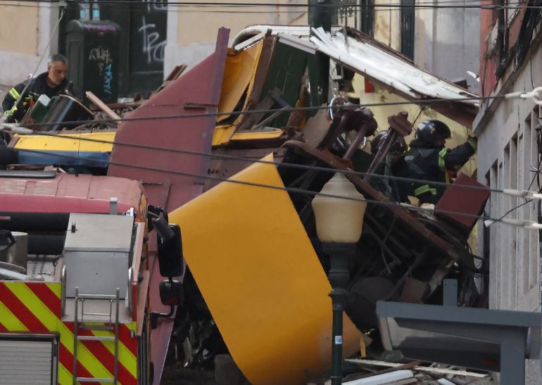 Police and firefighters work on the site of the Gloria funicular