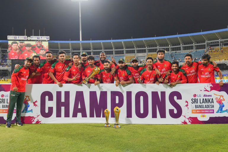 Bangladesh's team members pose for photographers with the winner's trophy after the third Twenty20 cricket match against Sri Lanka