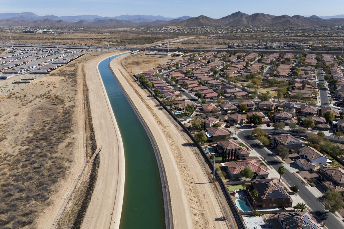 Colorado River water flows in the Central Arizona Project aqueduct beside a neighborhood in Phoenix.