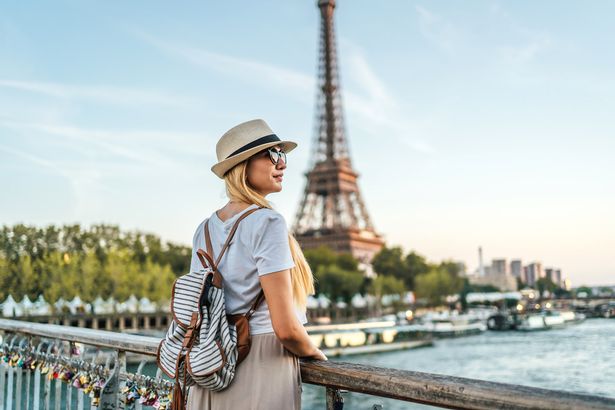 Young tourist woman enjoying in front of the Eiffel Tower and River Seine in Paris, France. Stock image.