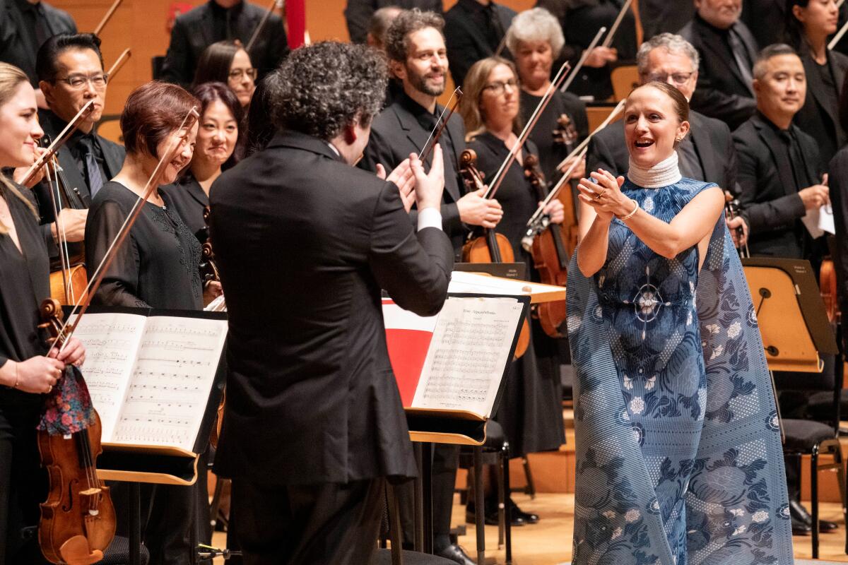 Gustavo Dudamel and the L.A. Philharmonic musicians applaud  one another