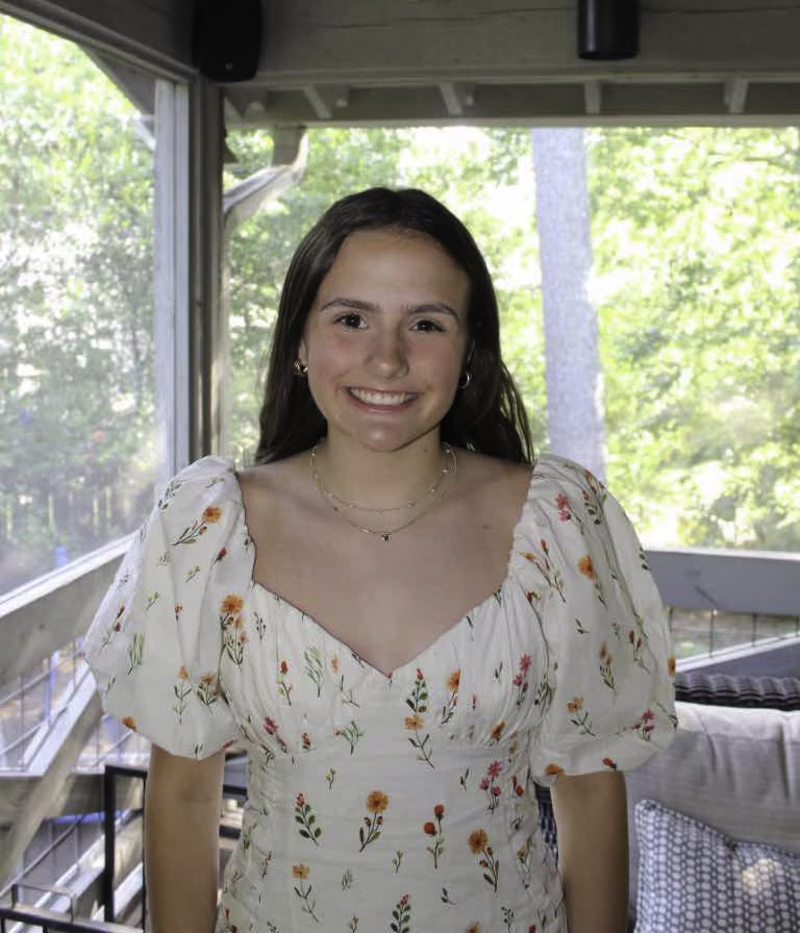Smiling girl in a floral dress.