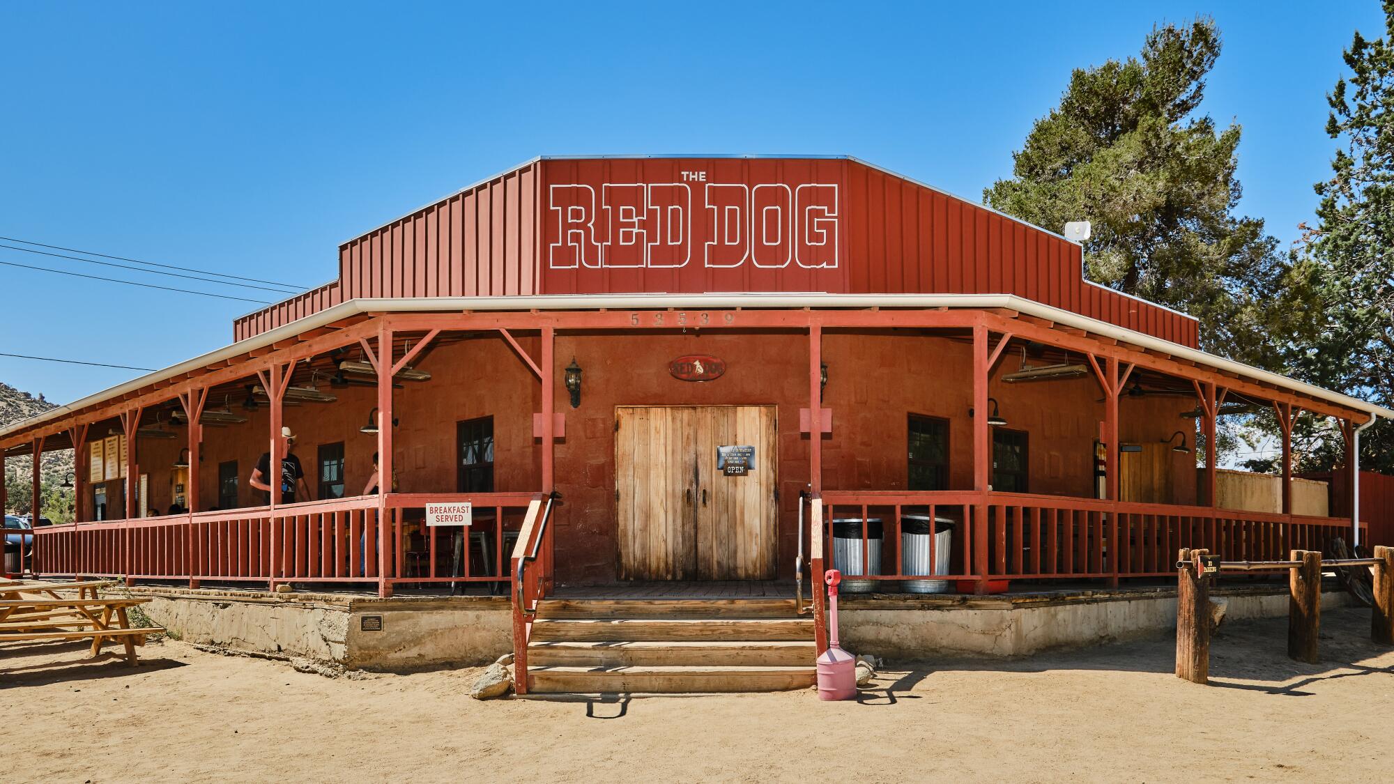 A red western looking building with a sign that says Red Dog.