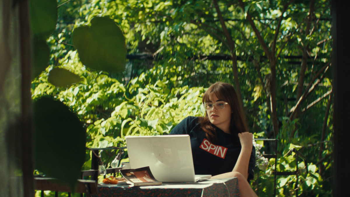 A woman writes an article on a laptop.