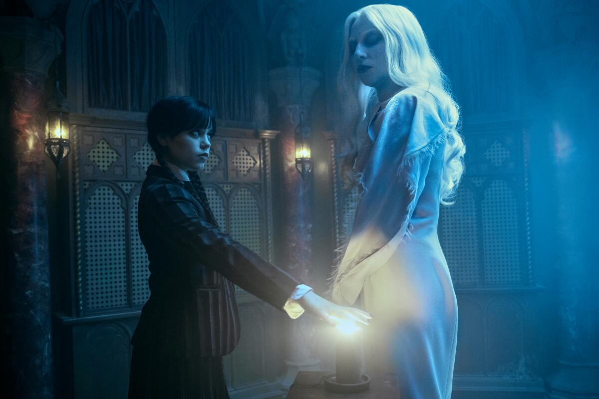 A young woman in black stands opposite a woman in white