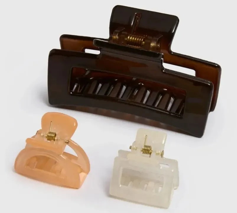 Three hair claw clips: one large dark brown, one small peach, and one small clear.
