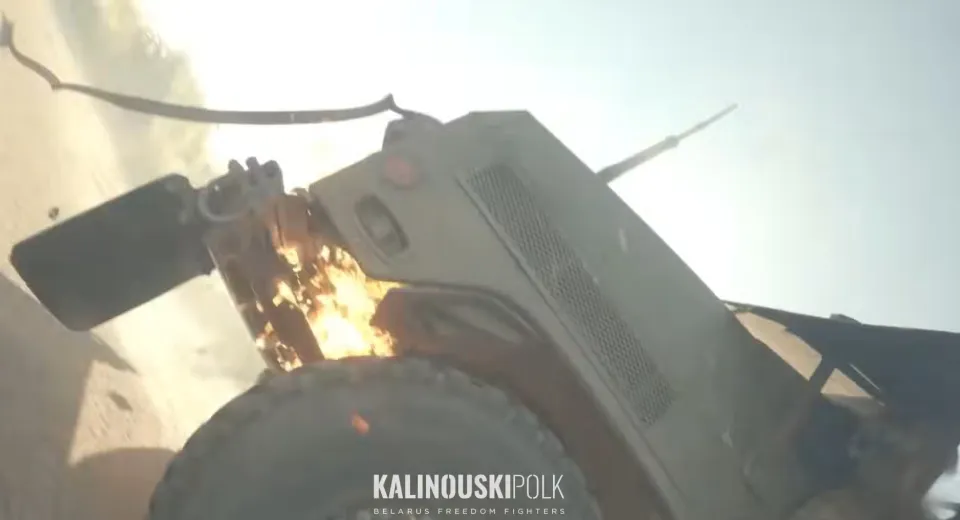 A military vehicle with its top ripped off, engulfed in flames and smoke.