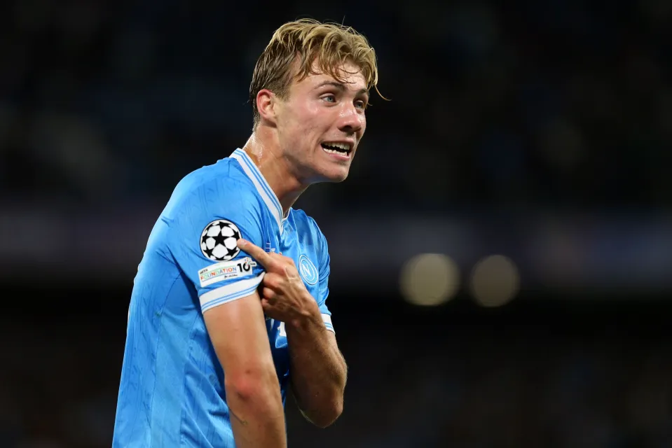 Rasmus Hojlund of SSC Napoli celebrating a goal and pointing to the UEFA Champions League patch on his sleeve.