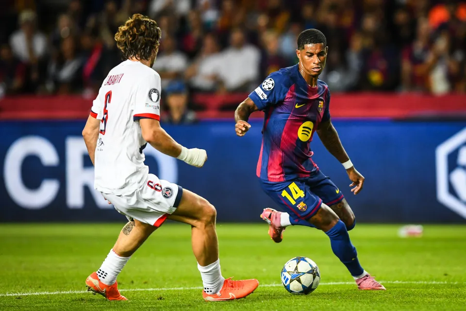 Marcus Rashford of FC Barcelona with the ball, facing an opponent from Paris Saint-Germain during a UEFA Champions League match.