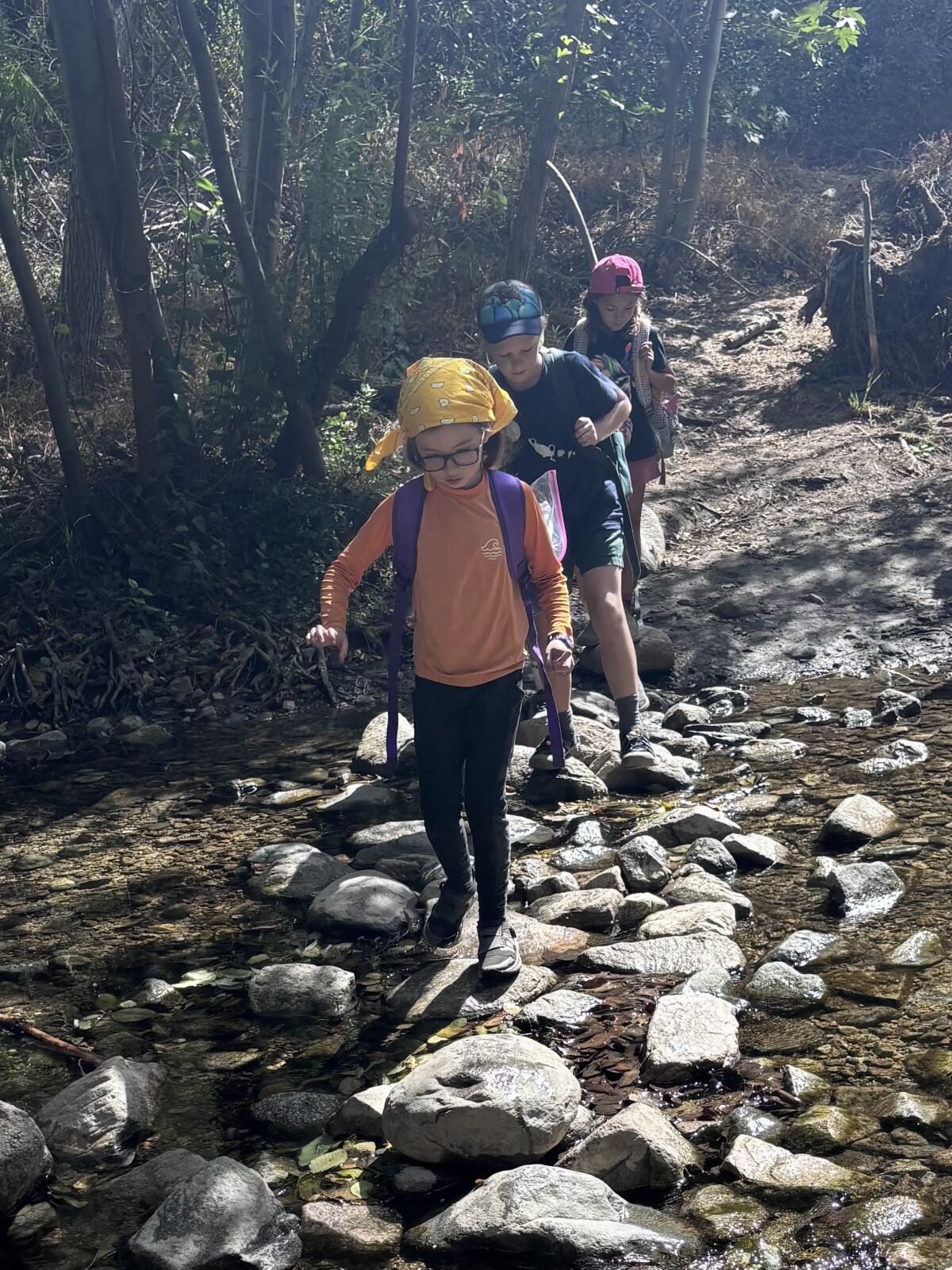 Children from HAWKs, an L.A.-based company that takes kids on outdoors adventures, cross the Arroyo Seco near Pasadena.