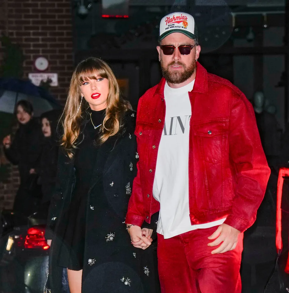 Taylor Swift and Travis Kelce holding hands while walking outdoors.