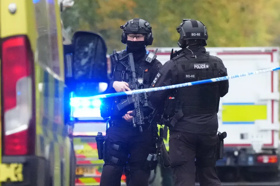 Armed police and emergency responders gather in Crumpsall, Manchester, England.