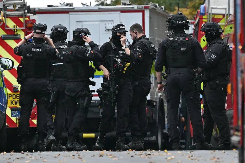 Armed police officers stand by emergency vehicles outside Heaton Park Hebrew Congregation synagogue following an attack.