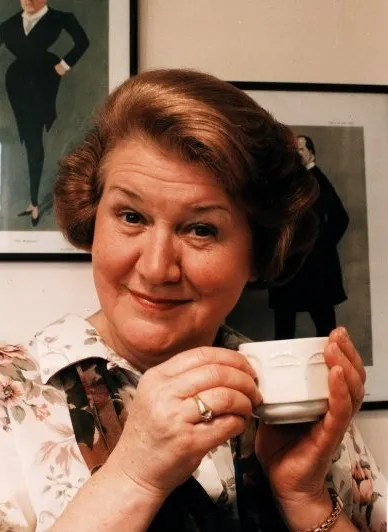 Patricia Routledge as Hyacinth Bucket holding a teacup.
