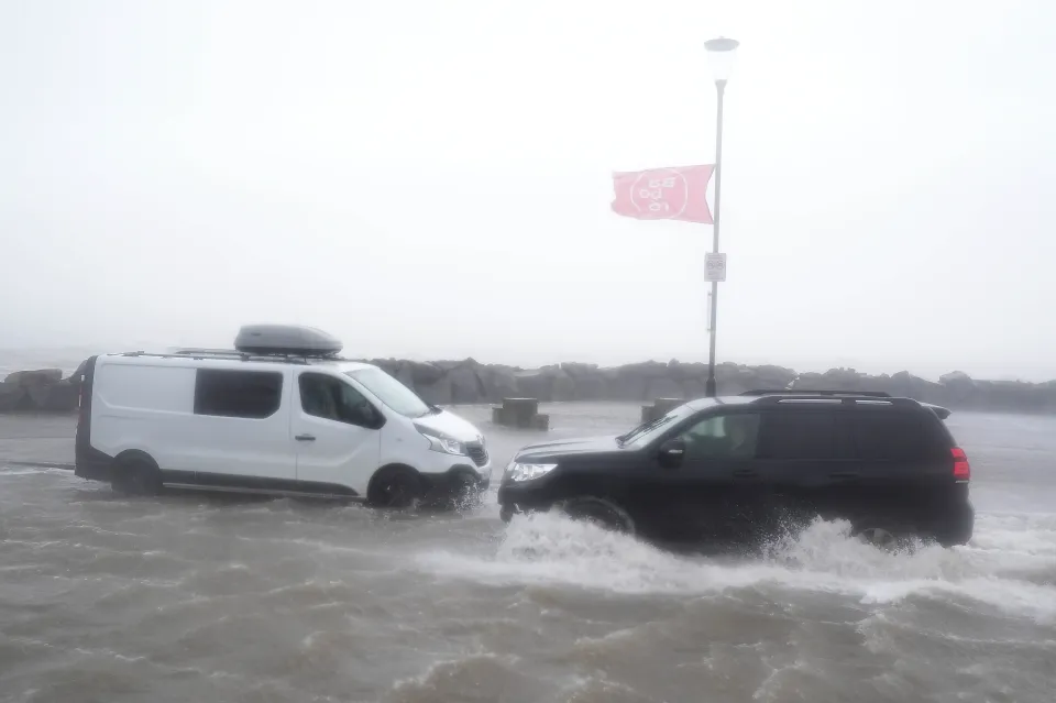 Two vehicles drive through floodwater in Galway during a storm.