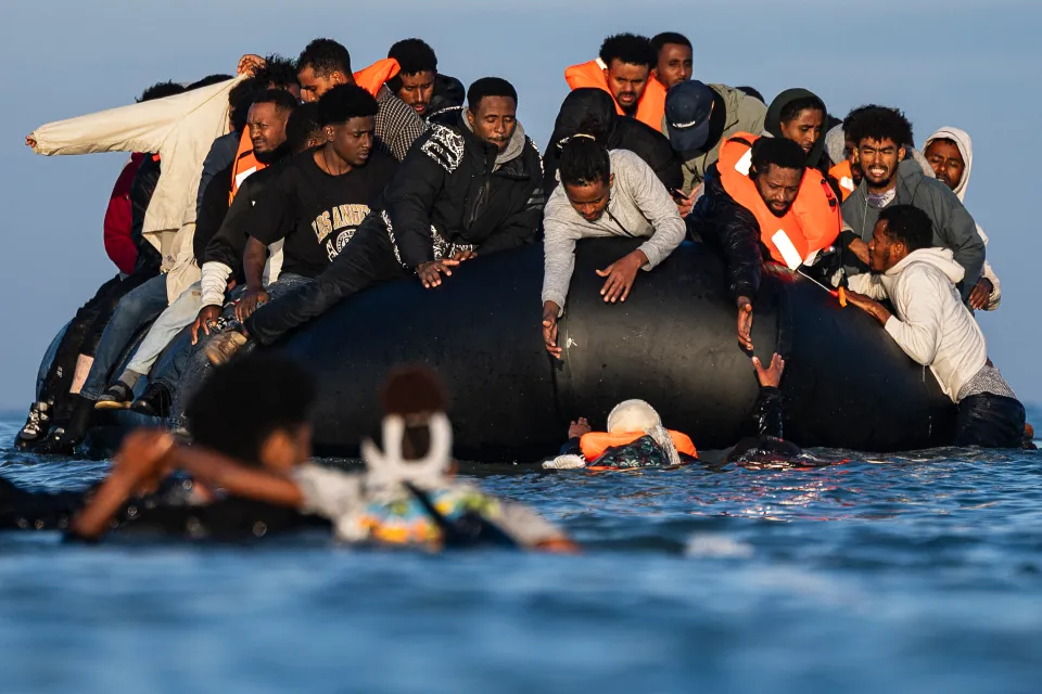 Migrants try to board smugglers' boats in an attempt to cross the English Channel off the beach of Gravelines, northern France.
