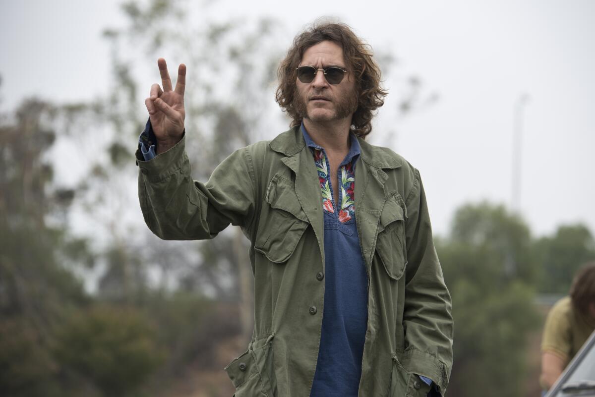A hippie in an army jacket raises a peace sign.